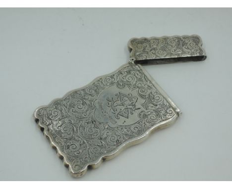 A Victorian silver card case having extensive engraved scroll decoration, monogrammed cartouche and shaped rims, Birmingham 1