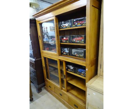 A modern hardwood 2-section display cabinet, with sliding glazed doors and cupboards to the base, width 150 cm