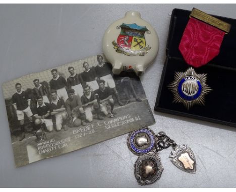 Box containing a silver and enamel Order of Buffaloes medal, 3 other silver fobs, a crested ware vase and football photograph