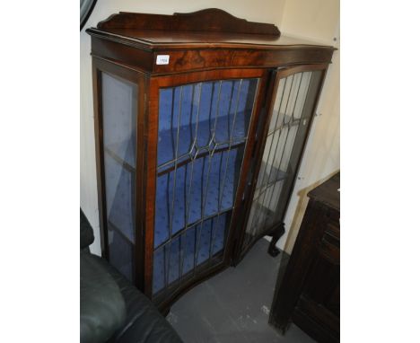 An Edwardian serpentine front walnut display cabinet with 2 leadlight glazed doors on claw and ball feet, width 104 cm