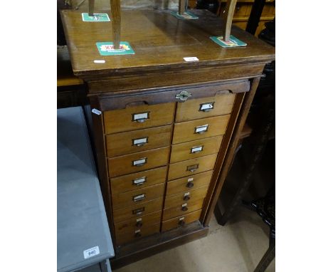 A Vintage oak Lebus filing cabinet, the tambour opening to reveal 16 fitted filing drawers, with original Lebus cabinet label