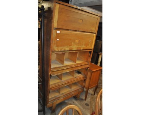 A 1920s oak floor standing cabinet, with 5 cantilever panelled doors revealing pigeon holes, width 92 cm