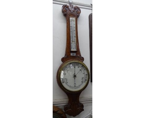 A carved oak-cased aneroid barometer  