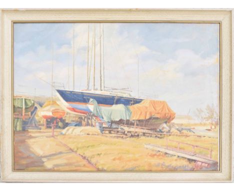K* Moseley - a boatyard with various vessels under cover, a larger yacht nearby and a coastline beyond, signed and dated 1980