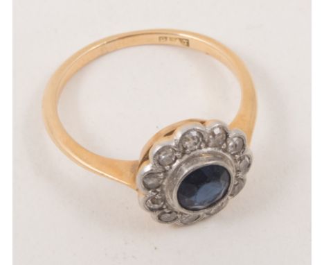 A sapphire and diamond circular ring, a circular sapphire surrounded by eleven old cut diamonds, yellow and white metal mount