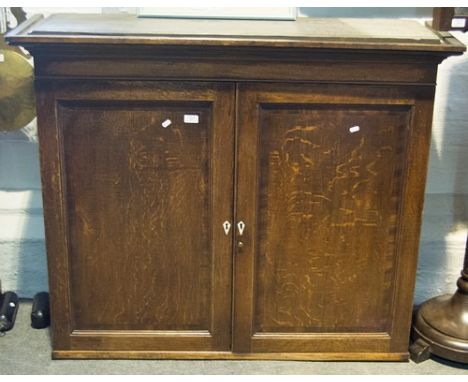 Oak bookcase top, moulded cornice, above two panelled doors, enclosing an adjustable shelf, width 123cm.