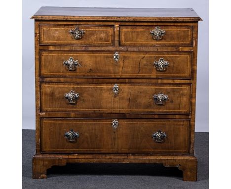 A George III walnut chest of drawers, rectangular top with herringbone stringing, broad cross-banding moulded edge, fitted wi