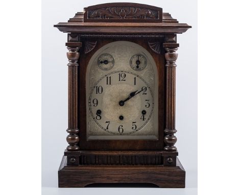 Three train mantel clock, domed carved oak case, arched silvered dial, height 44cm.