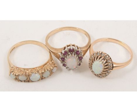 Three opal dress rings, a five stone half hoop in 9 carat yellow gold, ring size M, an oval cluster set with one opal surroun