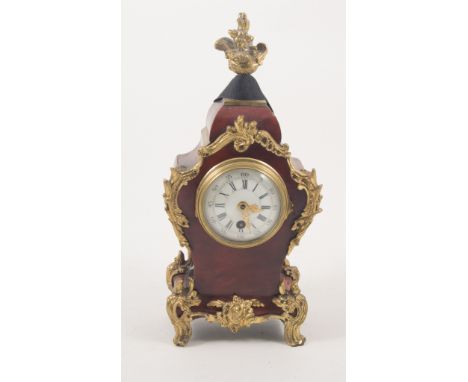 A small tortoiseshell mantel clock with gilded mounts, convex white enamel dial with arabic numeral chapter ring and outer ar