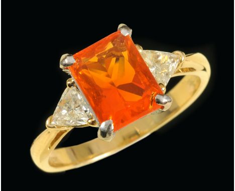 A Fire Opal and Diamond three stone Ring corner claw-set scissor-cut fire opal between two triangular-cut diamonds in 18ct go