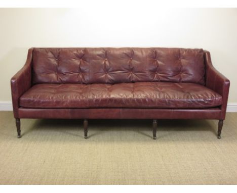 A large Victorian style Settee with red leather button upholstered cushions on four turned and fluted front legs and casters,