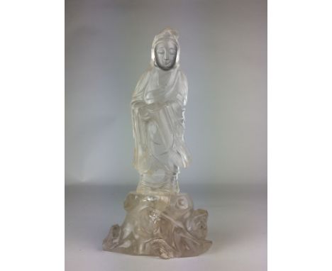 A Chinese rock crystal or quartz Figure of GuanyinLate Qing DynastyStanding on a rockwork base holding a scroll and dressed i