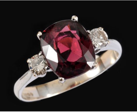 A Ruby and Diamond three stone Ring claw-set cushion-cut ruby between two brilliant-cut diamonds in 18ct white gold, ring siz