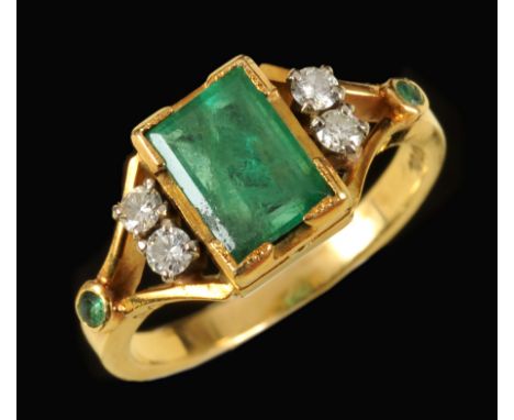 An Emerald and Diamond Ring rub over-set step-cut emerald between two pairs of brilliant-cut diamonds and small circular-cut 