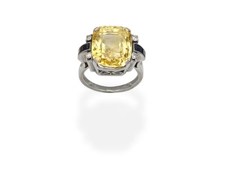 YELLOW SAPPHIRE AND DIAMOND RINGThe cushion-shaped yellow sapphire between shoulders set with calibré-cut sapphires, and bril