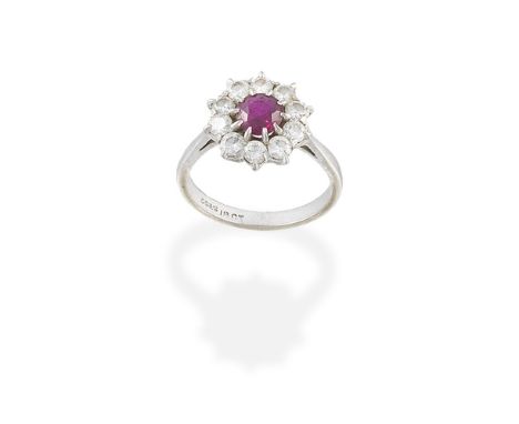 RUBY AND DIAMOND CLUSTER RINGSet with a circular-cut ruby, within a brilliant-cut diamond surround, ring size approx. MFor fu