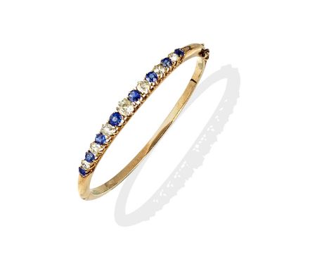 SAPPHIRE AND DIAMOND BANGLEThe hinged bangle set with alternating circular-cut sapphires and cushion-shaped diamonds, diamond