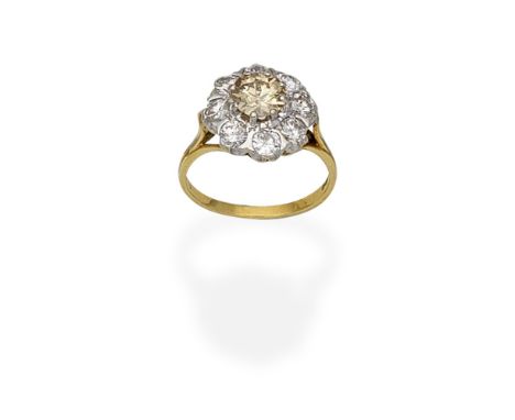 DIAMOND CLUSTER RING, 1975Set with an old brilliant-cut diamond of brown tint, within a brilliant-cut diamond surround, mount