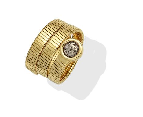 BULGARI: 'GEMME NUMMARIE' TUBOGAS BANGLE, CIRCA 1970The coiling sprung gaspipe-link bangle with an ancient Roman coin termina