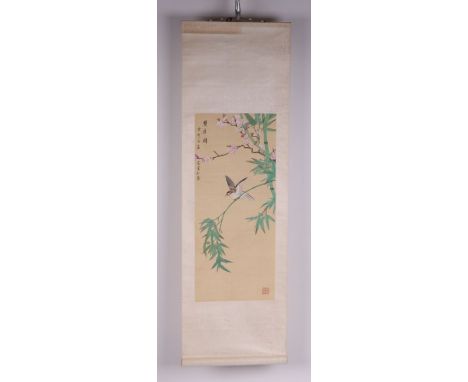 A Chinese scroll painting depicting a bird perched on bamboo with prunus and calligraphy, 26 by 58cms.