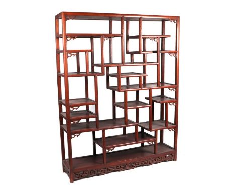A large Chinese hardwood multi level floor standing display shelf with carved details, 140cms wide, 180cms high and 36cms dep