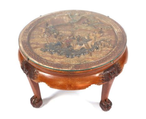 A Chinese carved hardwood coffee table, the top deeply carved with figures in a seascape, on lion mask capped legs and ball &