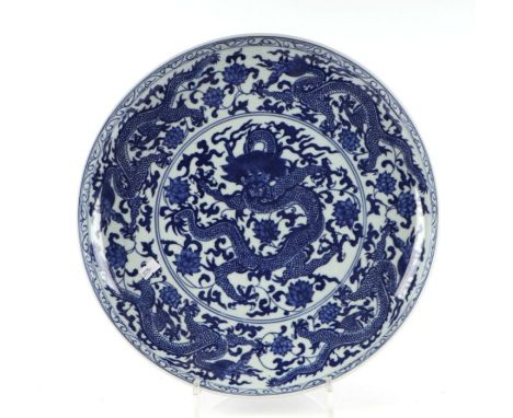 A large Chinese blue &amp; white shallow bowl decorated with dragons, blue seal mark to the underside, 37cms diameter.