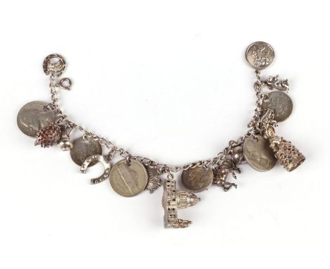 A silver charm bracelet with eighteen charms, 64g.