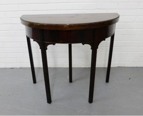 A mahogany demi lune card table, the circular top opening to reveal a green felt lining, raised on straight carved supports, 