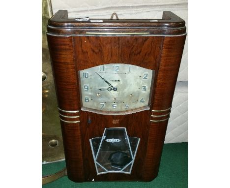 An Art Deco French Wall Clock by Vedette G Mullard; with chrome octagonal pendulum bob, with matching hands and numerals. The