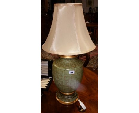 A Good Quality Green and Gold Patterned Ceramic Table Lamp; with yellow silk shade.