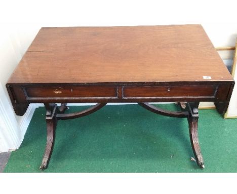 An Early 19th Century Mahogany Sofa Table; the beaded frieze fitted with a drawer and a false drawer to either side, on reede