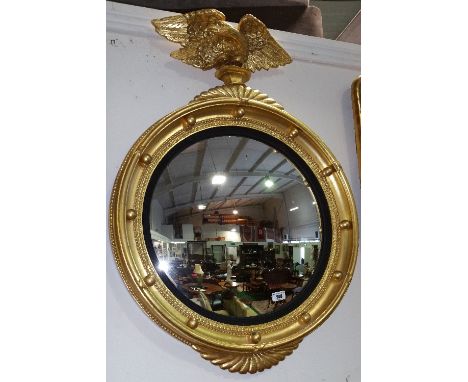 A Regency Style Gilt Convex Mirror with Eagle Finial.