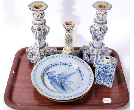 A pair of Delft candlesticks; a Delft caddy painted with an armorial; two Delft plates and a further tin glazed candlestick