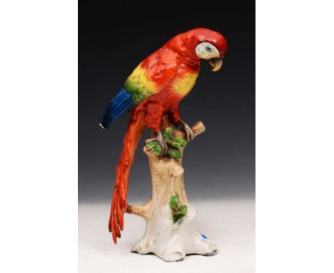 A SITZENDORF MODEL of a parrot sitting on a tree trunk, 28cm high