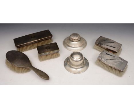 A COLLECTION TO INCLUDE: a silver circular Capstan inkwell, another plated, and five silver backed brushes with engine turned