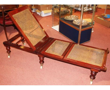 A VICTORIAN MAHOGANY FOLDING CAMPAIGN DAY BED with cane seat and back on ring turned legs and ceramic castors labelled Robins