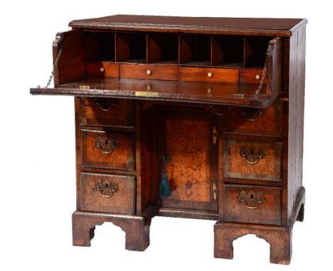 AN 18TH CENTURY KNEEHOLE WRITING DESK, the long drawer fitted pigeon holes and small drawers enclosed by a fall front with kn