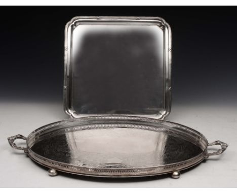 A SILVER PLATED OVAL TWO HANDLED BUTLERS TRAY with engraved decoration and bun feet, 63cm wide; and a square silver plated dr