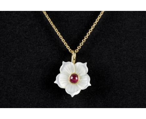 'antique' flower shaped pendant in mother of pearl with a central small cabochon cut ruby, set in yellow gold (18 carat) & wi