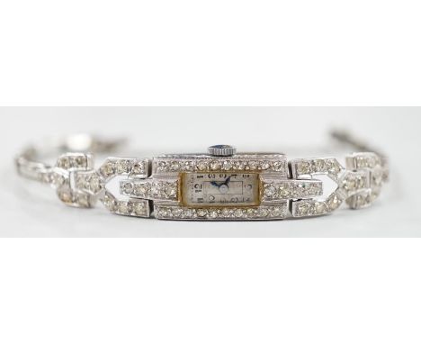 A lady's platine and diamond cluster set manual wind cocktail watch, with rectangular Arabic dial, on a white metal expanding