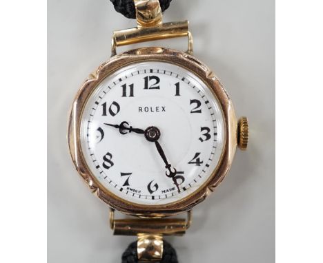 A lady's 1920's 9ct gold Rolex manual wind wrist watch, on associated fabric strap.