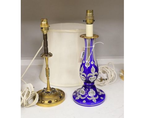 A Bohemian blue and white overlaid glass pedestal converted to a table lamp, together with a gilt brass table lamp, inset wit