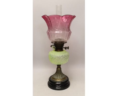 A Victorian brass and glass oil lamp, with cranberry shade, 58cm high including funnel