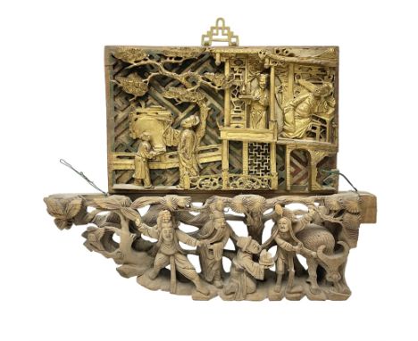 Two carved oriental wall hangings, the first example gilded depicting a temple and garden scene, the second figures in a gard