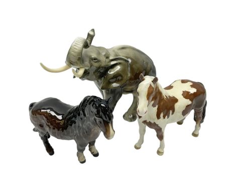 Three Beswick figures, comprising Skewbald Pinto Pony no 1373, Shetland pony mare, model 1033 and Elephant with trunk raised,