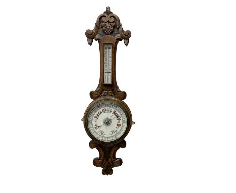 English - Edwardian aneroid barometer in a carved scroll work oak case, with a mercury box thermometer recording room tempera