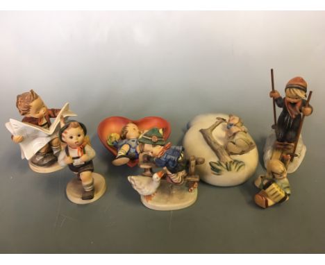 Five Goebel figurines including boy reading newspaper, girl playing accordion, boy skiing, etc, with a wall pocket and hangin