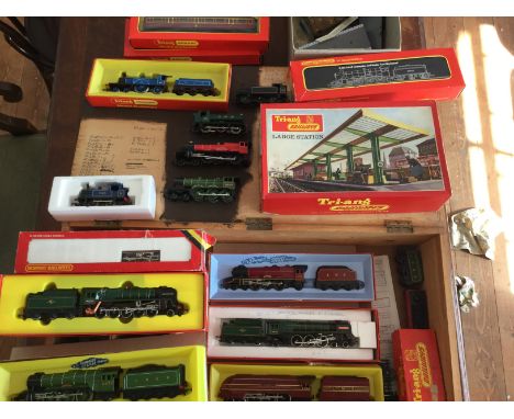 A collection of model railway items including thirteen Tri-ang locomotives, a large station, various coaches and cars, twin s